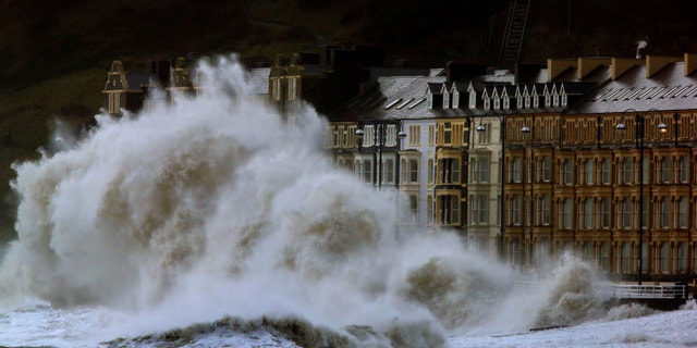 Waves crash against the Aberystwyth coastline in Wales, as strong winds and high tides continue to blow in from the west.