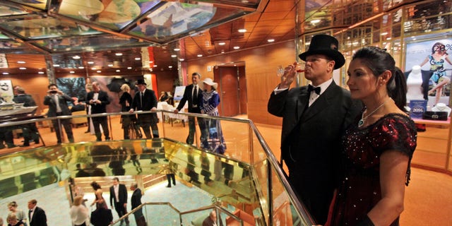 Passengers, some in costumes and evening dress, walk around the MS Balmoral Titanic memorial cruise ship, prior to the gala dinner in the Atlantic Ocean, Friday, April 13, 2012. Nearly 100 years after the Titanic went down, the cruise with the same number of passengers aboard is setting sail to retrace the ship's voyage, including a visit to the location where it sank. The Titanic Memorial Cruise departed Sunday, April 8, from Southampton, England, where the Titanic left on its maiden voyage and the 12-night cruise will commemorate the 100th anniversary of the sinking of the White Star liner early Sunday, April 15, 2012. AP Photo/Lefteris Pitarakis)