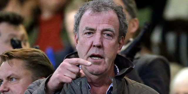 FILE - In this Wednesday, March 11, 2015 file photo TV host Jeremy Clarkson gestures as he takes his place in the stands before the Champions League round of 16 second leg soccer match between Chelsea and Paris Saint Germain at Stamford Bridge stadium in London. Clarkson, the former host of hit BBC auto show "Top Gear," has apologized and paid an undisclosed sum to a producer he punched in an off-set altercation it was reported on Wednesday, Feb. 24, 2016. Clarkson was fired in March 2015 after hitting Oisin Tymon during a dispute at the end of a day's filming. (AP Photo/Matt Dunham, File)