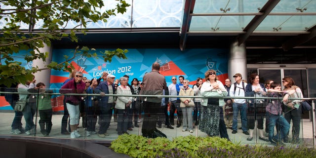 June 13, 2012: In this photo tour guide Andy Rashleigh, back to camera, talks to his tour group near the London 2012 Olympic Park.