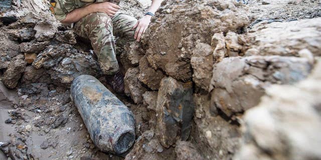 An army bomb disposal expert inspects an unexploded World War II bomb found in Wembley, north London, Thursday May 21, 2015. The 50-kilogram (110-pound) bomb was discovered by workers at a construction site near Wembley stadium. It is believed to have been dropped over London during German bombing raids in the early 1940s. (Sergeant Rupert Frere of the Royal Logistic Corrps/MoD Crown Copyright via AP) NO SALES