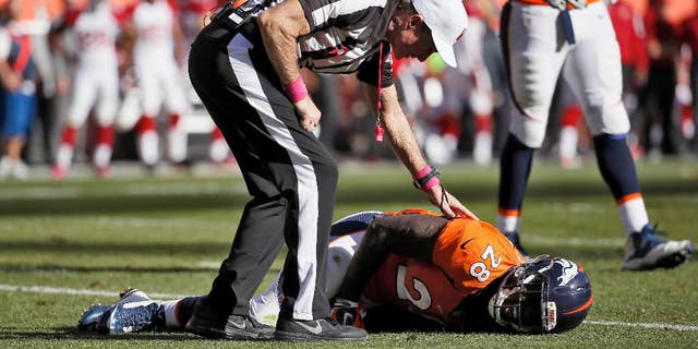 FILE - In this Oct. 5, 2014, file photo, a referee checks on injured Denver Broncos running back Montee Ball (28) during the second half of an NFL football game against the Arizona Cardinals in Denver. Ball was Mr. Durability at the University of Wisconsin, missing just one game while scoring an NCAA record 83 touchdowns. He hasn't had the same endurance in the NFL. (AP Photo/Jack Dempsey, File)