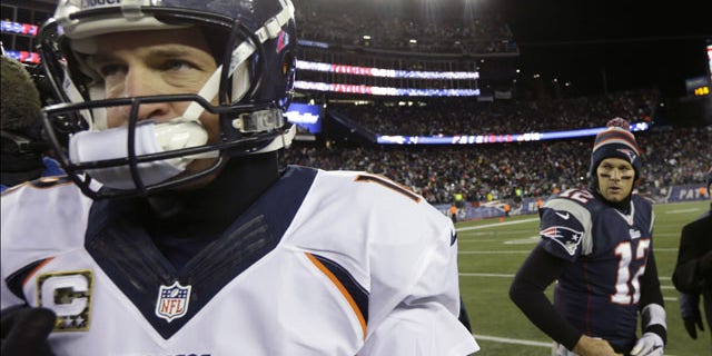 November 25, 2013: Denver Broncos quarterback Peyton Manning, left, walks from New England Patriots quarterback Tom Brady after an NFL football game in Foxborough, Mass. The Patriots won 34-31 in overtime. (AP Photo/Steven Senne)