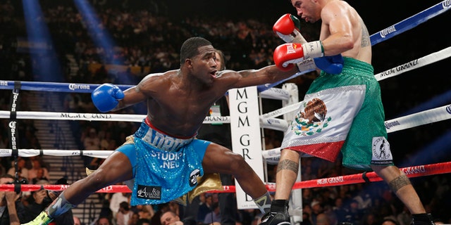 Adrien Broner, left, from Cincinnati, Ohio, throws a left to the body of Carlos Molina, from Norwalk, Calif., in their WBA super lightweight title boxing fight Saturday, May 3, 2014, in Las Vegas. (AP Photo/Eric Jamison)