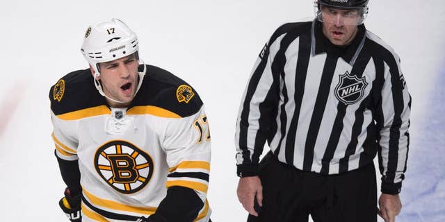 Boston Bruins' Milan Lucic, left, reacts as he is escorted off the ice by linesman Michel Cormier after receiving a penalty near the end of an NHL hockey game against the Montreal Canadiens, Thursday, Oct. 16, 2014, in Montreal. The Canadiens won 6-4. (AP Photo/The Canadian Press, Paul Chiasson)