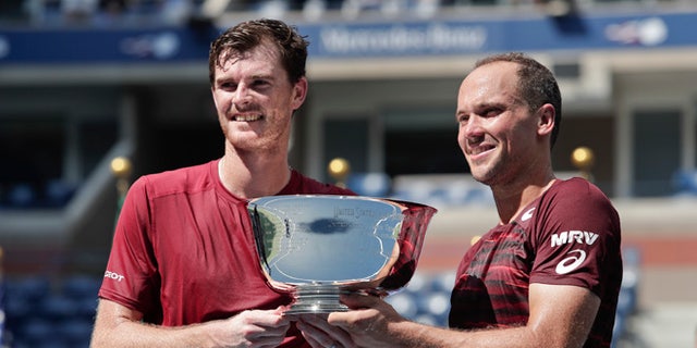 Jamie Murray, of the United Kingdom, left, and Bruno Soares, of Brazil, pose for a photo with the championship trophy after beating Pablo Carreno Busta, of Spain, and Guillermo Garcia-Lopez, of Spain, to win the men's doubles final of the U.S. Open tennis tournament, Saturday, Sept. 10, 2016, in New York. (AP Photo/Julie Jacobson)