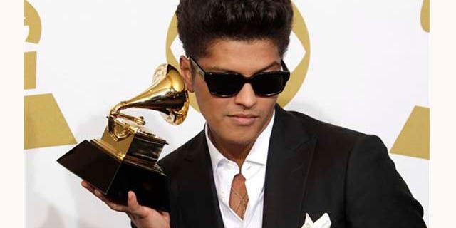 Bruno Mars poses backstage with the award for best male pop vocal performance at the 53rd annual Grammy Awards on Sunday, Feb. 13, 2011, in Los Angeles. (AP Photo/Jae C. Hong)