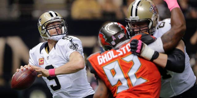 New Orleans Saints quarterback Drew Brees (9) drops back to pass under pressure from Tampa Bay Buccaneers defensive end William Gholston (92) in the first half of an NFL football game in New Orleans, Sunday, Oct. 5, 2014. (AP Photo/Bill Haber)