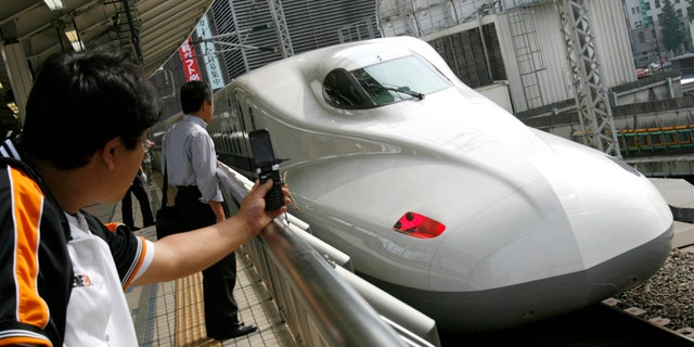 File photo - Men look at Japan Railway's N700 bullet train standing at a platform of Tokyo Station in Tokyo July 6, 2007.