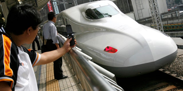 File photo - Men look at Japan Railway's N700 bullet train standing at a platform of Tokyo Station in Tokyo July 6, 2007.