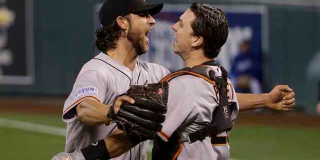 October 29 ,2104: San Francisco Giants pitcher Madison Bumgarner, left, and Buster Posey celebrate after defeating the Kansas City Royals in Game 7 of baseball's World Series in Kansas City, Mo. (AP Photo/Matt Slocum)