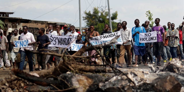 May 1, 2015 - Demonstrators walk over a street barricade in the Musaga neighborhood of Bujumbura, Burundi. Anti-government street demonstrations continued for a 6th day in protest against the move by President Pierre Nkurunziza to seek a third term in office.