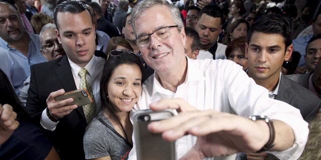 FILE: April 28, 2015: Probable 2016 GOP presidential candidate and former Florida Gov. Jeb Bush (white shirt) poses for a selfie during a town hall meeting in San Juan, Puerto, Rico.