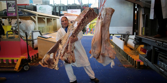 Butchers unload sides of beef at the 2018 Paris International Agricultural Show as farmers and their animals prepare for the opening of the farm show in Paris, France, February 23, 2018.