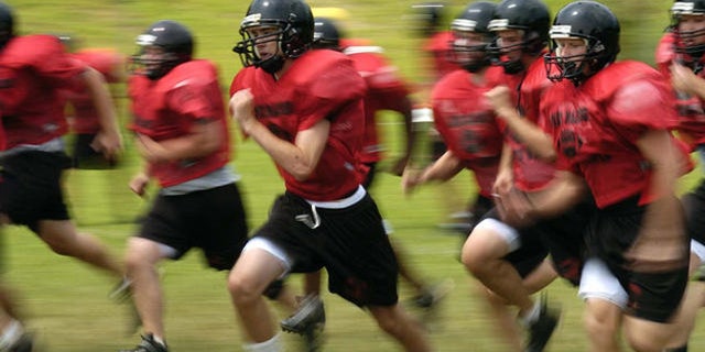 Madison High School football players run sprints during a half pad practice on Friday, Aug. 11, 2006, in Vienna, Va. It's that time of year: Kids hit the ball fields running, and often hobble or are carried off. Back to school means back to organized sports for more than 30 million children and teenagers, and roughly 2.6 million emergency-room visits during the year for resulting injuries. Basketball, football and soccer lead the list of injury-prone team sports. (AP Photo/Kevin Wolf)
