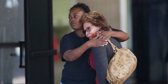 Two women embrace at a community center where family members are gathering to pick up survivors after a shooting rampage that killed multiple people and wounded others at a social services center in San Bernardino, Calif., Wednesday, Dec. 2, 2015. (AP Photo/Jae C. Hong)