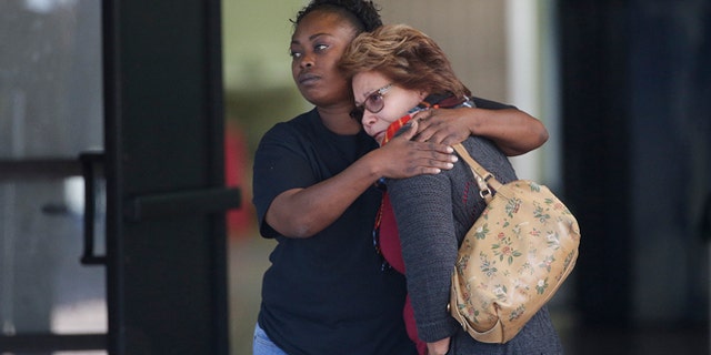 Two women embrace at a community center where family members are gathering to pick up survivors after a shooting rampage that killed multiple people and wounded others at a social services center in San Bernardino, Calif., Wednesday, Dec. 2, 2015. (AP Photo/Jae C. Hong)