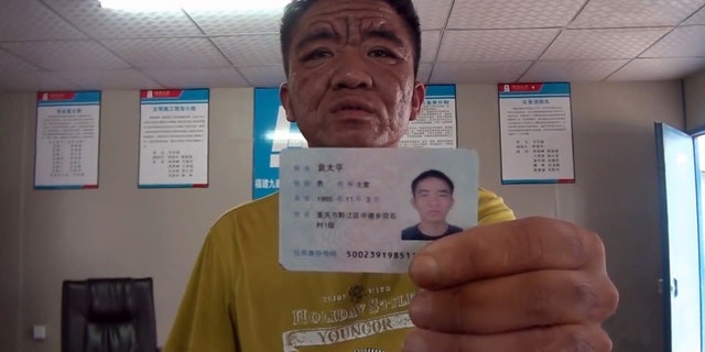 Yuan Taiping showing his ID; year of birth: 1985. (CEN)