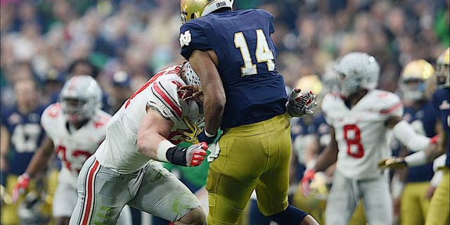 Jan 1, 2016; Glendale, AZ, USA; Ohio State Buckeyes defensive lineman Joey Bosa (97) hits Notre Dame Fighting Irish quarterback DeShone Kizer (14) during the first half of the 2016 Fiesta Bowl at University of Phoenix Stadium. Bosa would be penalized for targeting and ejected from the game. Mandatory Credit: Joe Camporeale-USA TODAY Sports
