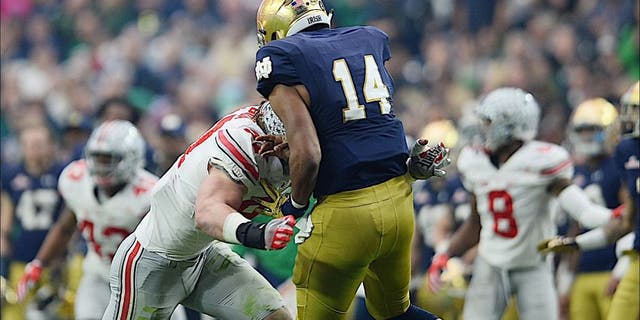 Jan 1, 2016; Glendale, AZ, USA; Ohio State Buckeyes defensive lineman Joey Bosa (97) hits Notre Dame Fighting Irish quarterback DeShone Kizer (14) during the first half of the 2016 Fiesta Bowl at University of Phoenix Stadium. Bosa would be penalized for targeting and ejected from the game. Mandatory Credit: Joe Camporeale-USA TODAY Sports