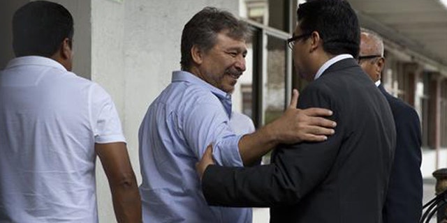 A member of a negotiation group comprised of protesting teachers and a mediation commission greets a government worker as he enters the Interior Ministry for a meeting with Secretary of the Interior Miguel Angel Osorio Chong, in Mexico City, Wednesday, June 22, 2016. The negotiations between the striking radical teachers and the government come three days after a clash between protestors and police in Oaxaca state left eight dead. Though who started shooting is disputed, journalists filmed police firing their weapons in the confrontation, which also left more than 100 injured. (AP Photo/Rebecca Blackwell)