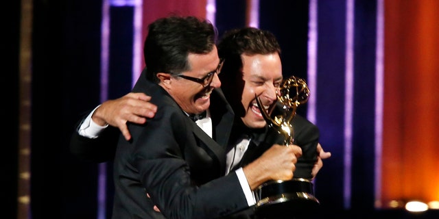 Stephen Colbert (L) and Jimmy Fallon celebrate after Colbert accepted the award for Outstanding Variety Series for Comedy Central's "The Colbert Report" onstage during the 66th Primetime Emmy Awards in Los Angeles, California August 25, 2014.  REUTERS/Mario Anzuoni (UNITED STATES - Tags: Entertainment)(EMMYS-SHOW) - RTR43QQ0