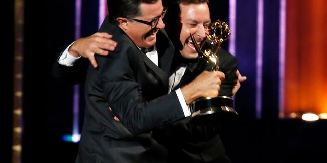 Stephen Colbert (L) and Jimmy Fallon celebrate after Colbert accepted the award for Outstanding Variety Series for Comedy Central's "The Colbert Report" onstage during the 66th Primetime Emmy Awards in Los Angeles, California August 25, 2014. REUTERS/Mario Anzuoni (UNITED STATES - Tags: Entertainment)(EMMYS-SHOW) - RTR43QQ0