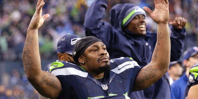 CORRECTS TO WILSON GAINING A FIRST DOWN, NOT SCORING A TOUCHDOWN - Seattle Seahawks running back Marshawn Lynch (24) gestures as Seahawks quarterback Russell Wilson runs for a first down against the New York Giants in the second half of an NFL football game, Sunday, Nov. 9, 2014, in Seattle. The Seahawks scored a touchdown on the drive. (AP Photo/Elaine Thompson)