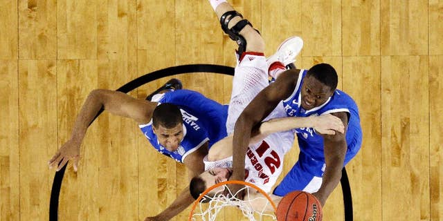 CORRECTS WISCONSIN PLAYER TO JOSH GASSER, INSTEAD OF TRAEVON JACKSON - Wisconsin guard Josh Gasser is caught between Kentucky guard Aaron Harrison (2) and forward Julius Randle (30) during the first half of the NCAA Final Four tournament college basketball semifinal game Saturday, April 5, 2014, in Arlington, Texas. (AP Photo/David J. Phillip)