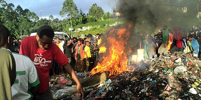 Feb. 6, 2013 - FILE photo: Hundreds of bystanders watch Kepari Leniata, a woman accused of witchcraft, being burned alive in the Western Highlands provincial capital of Mount Hagen in Papua New Guinea. There is no clear explanation for the apparent uptick in killings in parts of the South Pacific nation, and even government officials seem at a loss to say why this is happening. Some argue recent violence is fueled not by the nation's widespread belief in black magic but instead by economic jealousy.