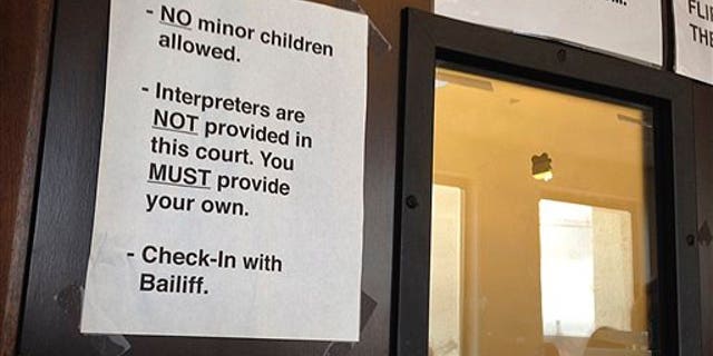 In this Wednesday, Aug. 5, 2015 photo, a sign stating no interpreters are provided is seen on the front door of the courtroom of Judge Don Franchi in San Mateo Superior Court in Redwood City, Calif. (AP Photo/Sudhin Thanawala)