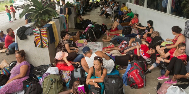 Cuban migrants sit outside a Costa Rican immigration building on the border with Nicaragua, in Peñas Blancas, Costa Rica, after Nicaragua closed its border to all Cuban migrants, leaving them stuck in Costa Rica. (AP Photo/Esteban Felix, File)