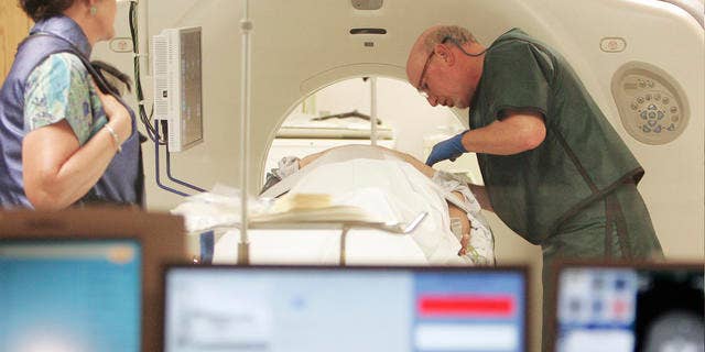 In this photo taken Thursday, June 3, 2010, Dr. Steven Birnbaum works a CT scanner with a patient at Southern New Hampshire Medical Center in Nashua, N.H. (AP Photo/Jim Cole)
