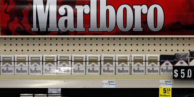 FILE - In this Wednesday, July 17, 2013 file photo, Marlboro cigarettes are on display in a CVS store in Pittsburgh. The nation's second-largest drugstore chain says it will phase out cigarettes, cigars and chewing tobacco by Oct. 1 as it continues to focus more on health care. The move will cost the Woonsocket, R.I., company about $2 billion in annual revenue. (AP Photo/Gene J. Puskar, File)