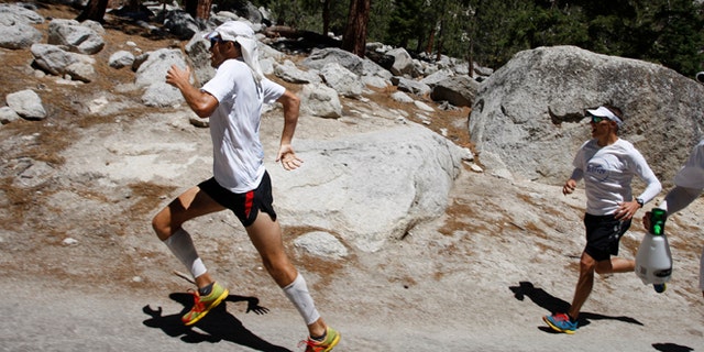 DEATH VALLEY NATIONAL PARK, CA - JULY 16: Harvey Sweetland Lewis III sprints hard, leaving his support crew behind, toward the finish to take fourth place in the AdventurCORPS Badwater 135 ultra-marathon race on July 16, 2013 outside of Death Valley National Park, California. Billed as the toughest footrace in the world, the 36th annual Badwater 135 starts at Badwater Basin in Death Valley, 280 feet below sea level, where athletes begin a 135-mile non-stop run over three mountain ranges in extreme mid-summer desert heat to finish at 8,350 feet above sea level near Mount Whitney for a total cumulative vertical ascent of 13,000 feet. July 10 marked the 100-year anniversary of the all-time hottest world record temperature of 134 degrees, set in Death Valley where the average high in July is 116. A total of 96 competitors from 22 nations attempted the run which equals about five back-to-back marathons. Previous winners have completed all 135 miles in less than 24 hours. (Photo by David McNew/Getty Images)
