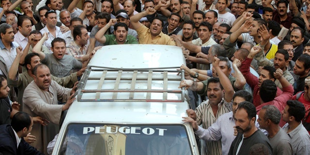 May 8, 2011: Angry Egyptian Christians surround a coffin of one of the victims, of Saturday night clashes with Muslims in the streets of Imbaba western Cairo, during a funeral ceremony at Giza church. Muslim mobs set two Cairo churches on fire overnight during sectarian clashes that left 12 dead and more than 200 injured.