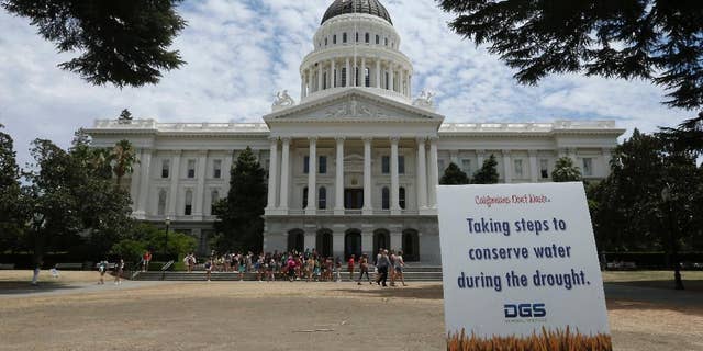 A sign alerts visitors to water conservation efforts at the state Capitol, Tuesday, July 8, 2014, in Sacramento, Calif. State water regulators are considering fines up to $500 for excessive water use for things like irrigating lawns and car washing due to the state's severe drought. (AP Photo/Rich Pedroncelli)
