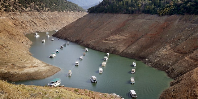 FILE - In this Thursday, Oct. 30, 2014, file photo, houseboats float in the drought-lowered waters of Oroville Lake near Oroville, Calif. Gov. Jerry Brown on Wednesday April 1, 2015 ordered sweeping and unprecedented measures to save water in California. Surveyors on Wednesday found the lowest snow level in the Sierra Nevada snowpack in 65 years of record-keeping, marking a fourth consecutive year of vanishing snow that California depends on to melt into rivers and replenish reservoirs.