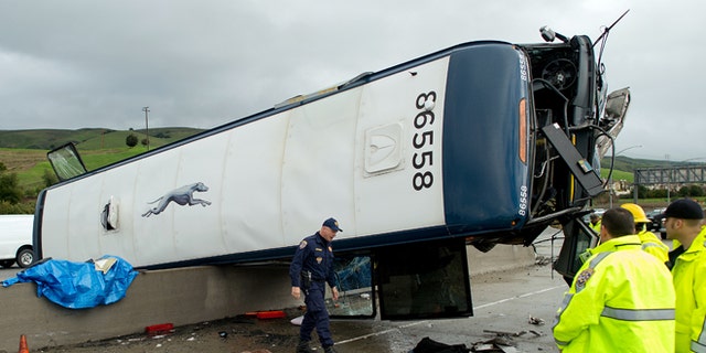 A California Highway Patrol investigator examines the scene of a fatal Greyhound bus crash, Tuesday, Jan. 19, 2016, in San Jose, Calif. The bus flipped on its side while traveling north on Highway 101, according to the San Jose Fire Department. (AP Photo/Noah Berger)