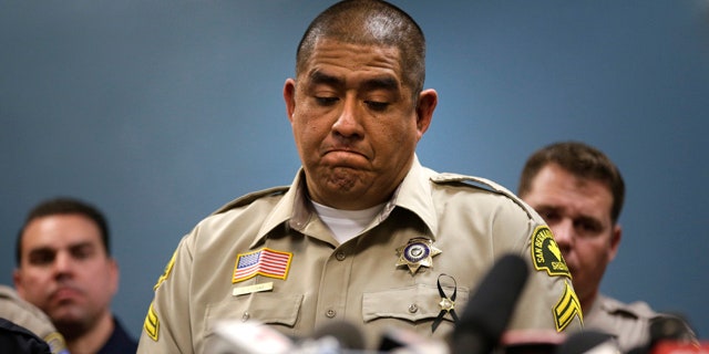 Dec. 8, 2015: San Bernardino County (Calif.) Sheriff's detective Jorge Lozano, center, pauses while answering questions during a news conference with the first responders on the scene of last week's fatal shooting at a social services center. (AP Photo/Jae C. Hong)