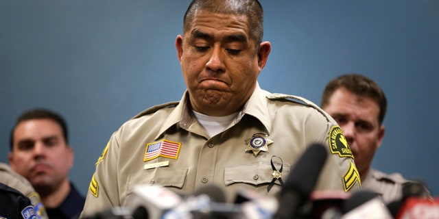 Dec. 8, 2015: San Bernardino County (Calif.) Sheriff's detective Jorge Lozano, center, pauses while answering questions during a news conference with the first responders on the scene of last week's fatal shooting at a social services center. (AP Photo/Jae C. Hong)