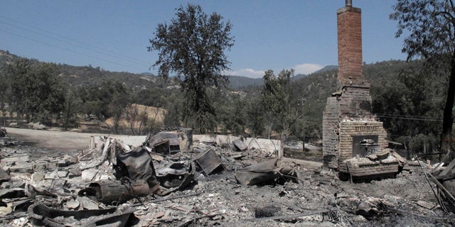 August 19, 2014: A chimney stands amid the remains of a burnt structure near Oakhurst, Calif. (AP Photo/Scott Smith)
