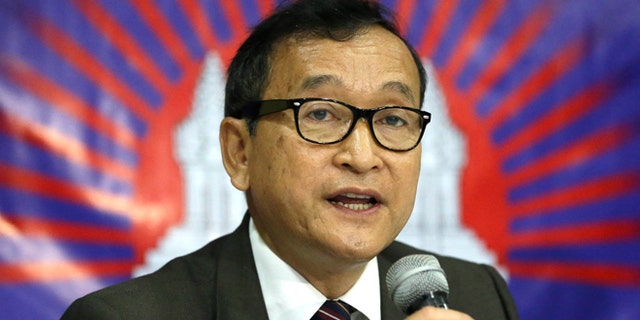 In this Sept. 10, 2012 file photo, Cambodian opposition leader Sam Rainsy, who was currently living in exile in France, talks about the opposition's plans for 2013 elections in Cambodia during the launching of the International Parliamentary Committee for Democratic Elections in Cambodia with Philippine Sen. Franklin Drilon in San Juan, east of Manila, Philippines.