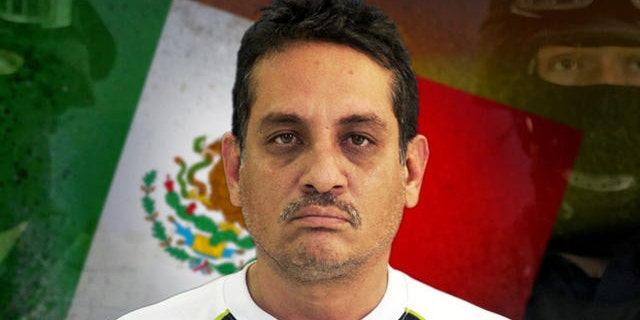 Jesus Ernesto Chavez, known as "El Camello" stands as he is guarded by federal police officers during a presentation to the press, in Mexico City, Friday, July 2, 2010. According to the federal police Chavez ordered the March 13 attack that killed a U.S. consulate employee and her husband as they drove in the violent border city. (AP Photo/Carlos Jasso)