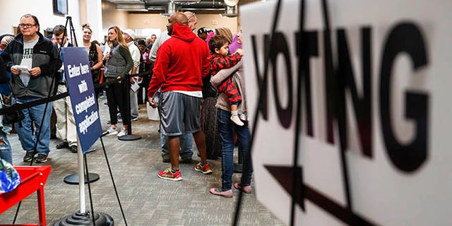 A line of early voters wait in queue at the Franklin County Board of Elections, Monday, Nov. 7, 2016, in Columbus, Ohio. Heavy turnout has caused long lines as voters take advantage of their last opportunity to vote before election day. (AP Photo/John Minchillo)