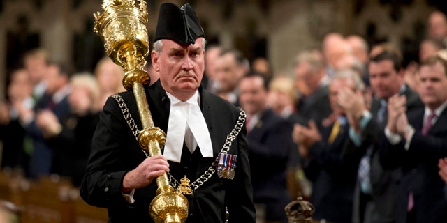 Oct. 23, 2014: Sergeant-at-Arms Kevin Vickers receives a standing ovation as he enters the House of Commons in Ottawa. (AP Photo/The Canadian Press, Adrian Wyld, File)