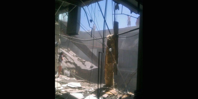 June 23, 2012: A woman checks out the damage after a roof collapsed at the Algo Centre Mall in Elliot Lake, Ontario.