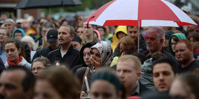 People take part in a candlelight vigil outside Royal Canadian Mounted Police headquarters in Moncton, New Brunswick, Canada on Friday, June 6, 2014. The RCMP say Justin Bourque, suspected in the shooting deaths of three Mounties and the wounding of two others in Moncton, was unarmed at the time of his arrest early Friday and was taken into custody without incident. (AP Photo/The Canadian Press, Sean Kilpatrick)