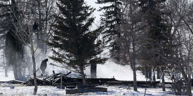 Feb. 25, 2015: Responders and investigators work at the scene of a fatal house fire near the rural community of Kane, Manitoba.