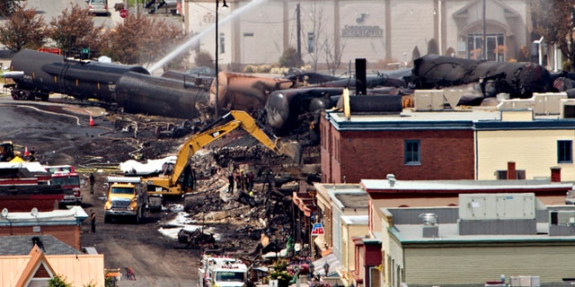 July 8, 2013: Searchers dig through the rubble for victims of the inferno in Lac-Megantic, Quebec as firefighter continue to hose down tanker cars to prevent explosions.